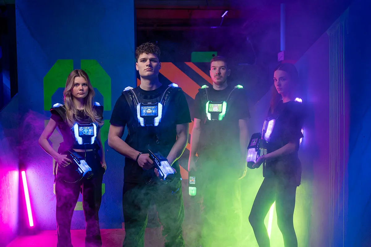 Gruppe von freunden spielt lasertag und posiert