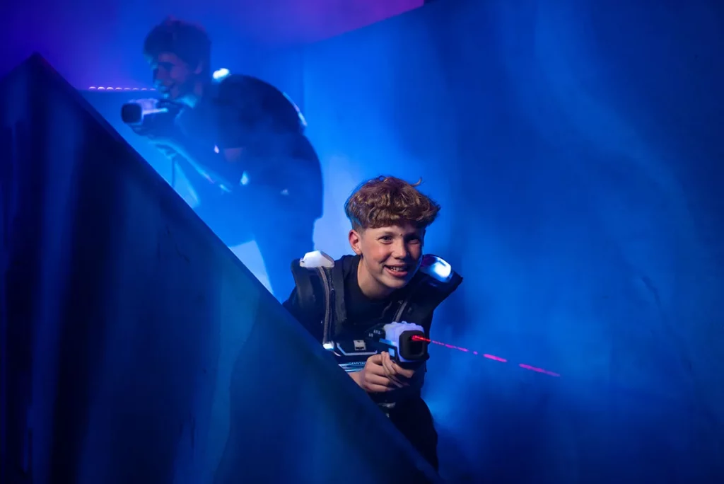 junge beim kindergeburtstag lasertag mit laser