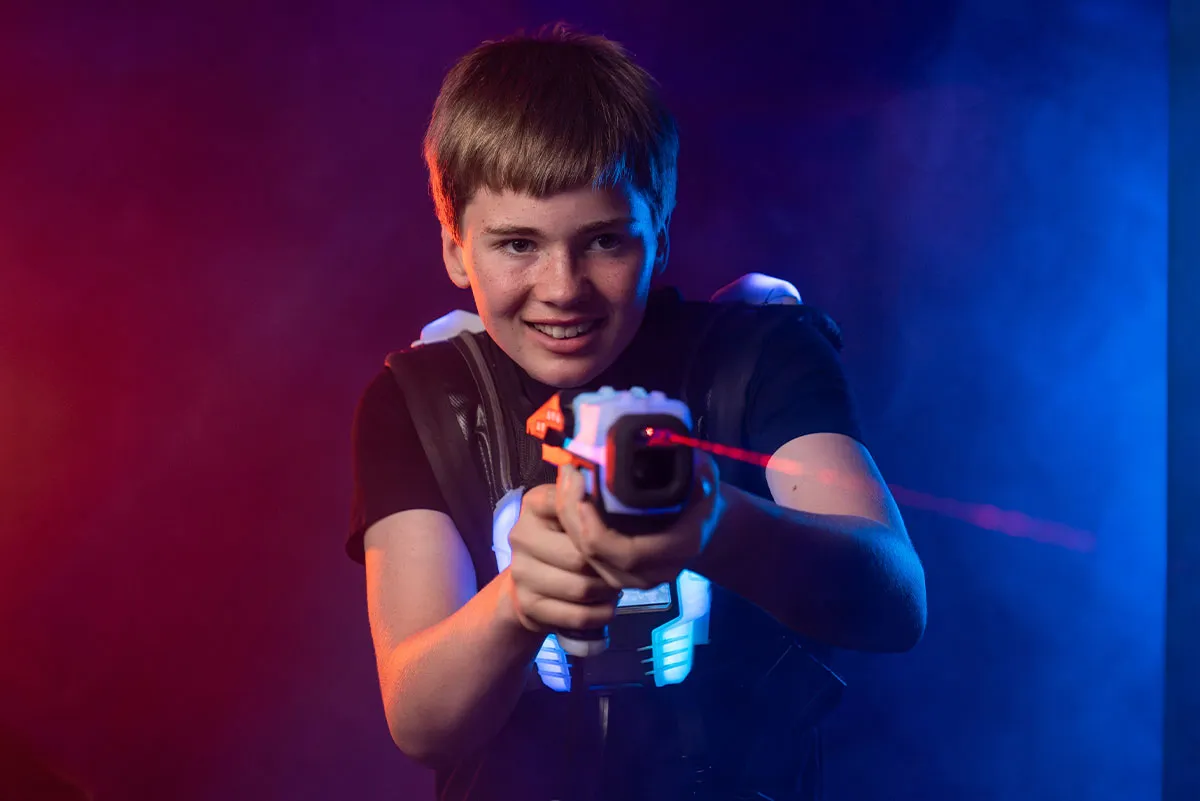 ein junge beim lasertag schulausflug zielt mit dem laser