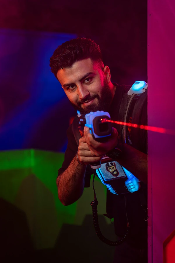 mann zielt um die ecke beim lasertag