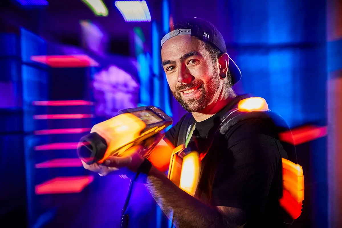 Mann beim Lasertag schaut in die kamera mit phaser